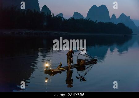 Pescatore cormorano con i suoi tre cormorani, li River, Xingping, Guilin, Cina Foto Stock