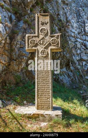 Croce di pietra ai piedi della parte orientale parete di scudo del medievale castello di Bran, casa del leggendario vampiro Conte Dracula, crusca, Transilvania, Romania Foto Stock