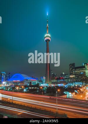CN Tower, Toronto, Ontario da notte con percorsi di luce che mostra Gardiner Expressway Foto Stock