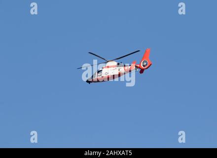 Il Coast Guard un elicottero che vola nel cielo blu oltre oceano, Galveston, Texas, Stati Uniti d'America Foto Stock