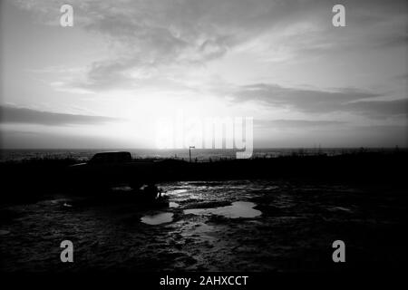 Vista sul mare oltre il torrente Chine parcheggio auto al Brook Beach Compton Bay sull'Isola di Wight che mostra un carrello parcheggiato e sentiero costiero segno segnaletica Foto Stock