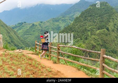 Cat Cat, Vietnam - Agosto 20, 2017: giovane donna nel tradizionale abito vietnamita in posa nella campagna circostante Foto Stock