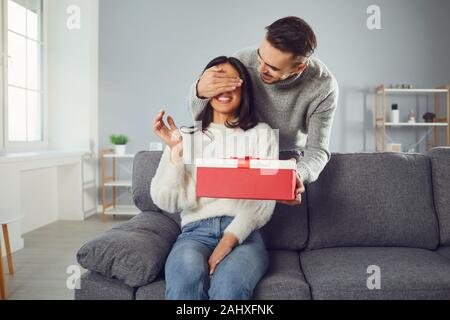 Il giorno di San Valentino. Una coppia giovane dà un dono in una stanza Foto Stock