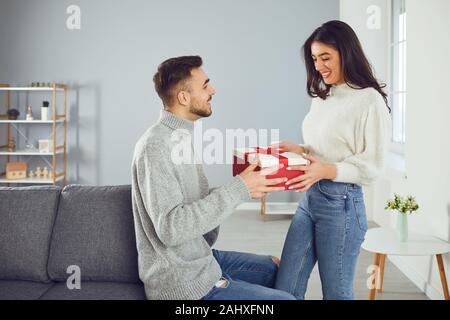 Il giorno di San Valentino. Una coppia giovane dà un dono in una stanza Foto Stock