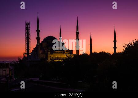 La Moschea Blu, Sultan Ahmed moschea, Sultan Ahmet Camii, con minareto circondato da impalcature, illuminate al tramonto Foto Stock