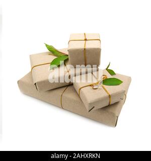 Quattro scatole confezionate in carta marrone con foglie naturali. Foto Stock