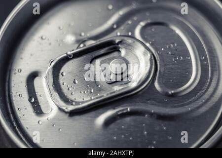 Chiuso di metallo possono di cola su sfondo nero. Vista dall'alto. Può bere con gocce d'acqua. Lucido in acciaio bottiglia di birra. Foto Stock