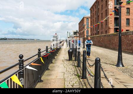 Royal Albert Dock Promenade, Liverpool, in Inghilterra, Regno Unito. Cunard liner "Queen Elizabeth" è ormeggiato a Liverpool Cruise Terminal in distanza. Foto Stock