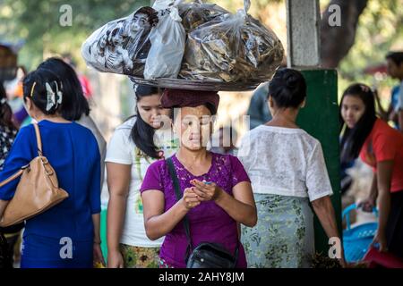 Yangon, Myanmar - 2 gennaio 2016: Una donna non identificata che vende pesce secco alla stazione ferroviaria. Foto Stock