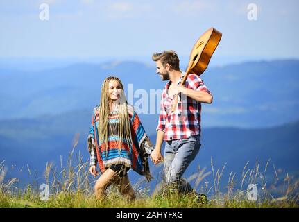 Escursionismo romance. Aria fresca e sentimenti puri. Passeggiata romantica. Canzone romantica. L'amore li ispira. Bella coppia romantica felice volti sorridenti sullo sfondo della natura. Ragazzo e ragazza con la chitarra. Foto Stock