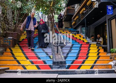 Una coppia di anziani in abito tradizionale si cammina in una maniera colorata scala dipinta nel sobborgo Karaköy Foto Stock