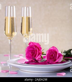 Due le rose rosa su valentine messa in tavola e bicchieri di champagne con spazio di copia Foto Stock