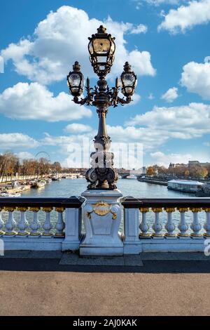 Antica lampada posta sul Pont d'Alexandre III, in francese con una torbida e il cielo sereno, Parigi, Francia Foto Stock