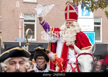 L'Aia, 16 novembre 2019 - Sinterklass (in olandese) in sella al suo cavallo sfilano in città annunciando il suo arrivo in città scortato dalla sua nera se Foto Stock