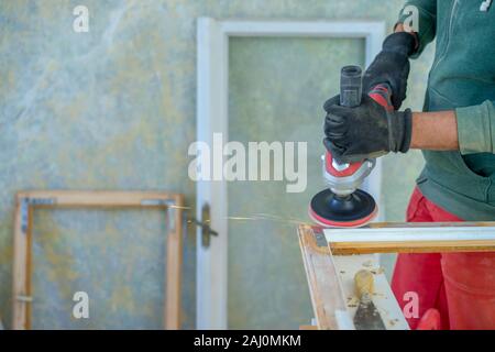 Uomo al lavoro per ripristinare vecchie finestre in legno Foto Stock