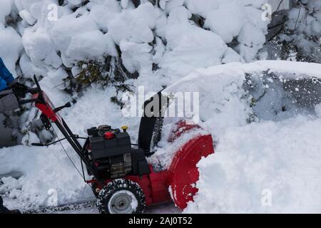 Un ventilatore di neve è la cancellazione di un viale di accesso dopo un inverno di blizzard su long island. Foto Stock