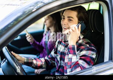 Adulto felice coppia che viaggia in auto mentre l uomo parla al telefono Foto Stock