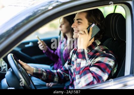 Adulto felice coppia che viaggia in auto mentre l uomo parla al telefono Foto Stock