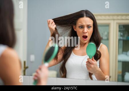 Giovane donna è in preda al panico a causa di perdita di capelli. Foto Stock