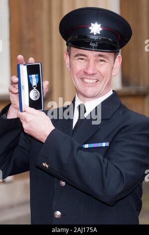 Firefighter Dean Seaward dopo la ricezione di una Regina Gallantry medal dalla regina in una cerimonia di investitura a Buckingham Palace. Foto Stock