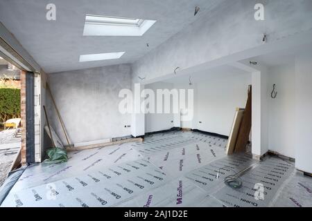 Un bianco vapore cappotto di vernice fresca di pareti intonacate in un prolungamento posteriore progetto presso una casa nel Cheshire Regno Unito Foto Stock