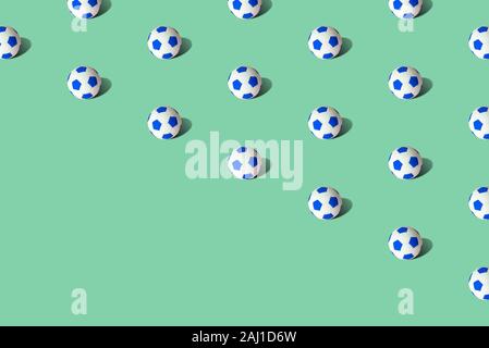 Palloni da calcio pattern su sfondo verde il minimo creative sport concept. Spazio per la copia. Foto Stock