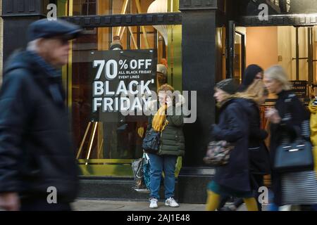 Gli amanti dello shopping a piedi i segni del passato per venerdì nero delle vendite in Chester city centre REGNO UNITO Foto Stock