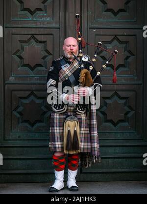 Lettore delle cornamuse busker al di fuori dell Alta Corte di Justiciary, Royal Mile di Edimburgo, Scozia, Regno Unito Foto Stock