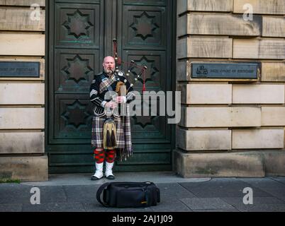 Lettore delle cornamuse busker al di fuori dell Alta Corte di Justiciary, Royal Mile di Edimburgo, Scozia, Regno Unito Foto Stock