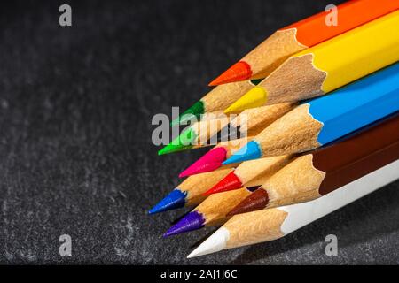 Matite colorate su sfondo nero, torna a scuola il concetto di sfondo con colore matite e copiare lo spazio per testo Foto Stock