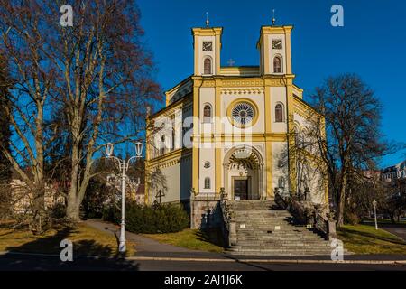 Marianske Lazne, Repubblica Ceca - 1 Gennaio 2020: vista della chiesa cristiana dell Assunzione della Vergine Maria con due torri su una soleggiata giornata invernale. Foto Stock