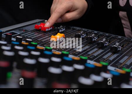 Donna mani di miscelazione da audio mixer audio analogico in studio di registrazione Foto Stock