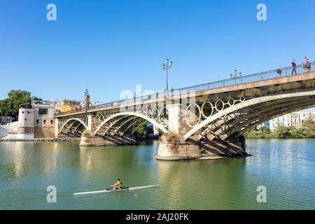 Vogatore passando sotto il Ponte di Triana sul fiume Guadalquivir, quartiere di Triana, Siviglia, Spagna, Andalusia, Spagna, Europa Foto Stock