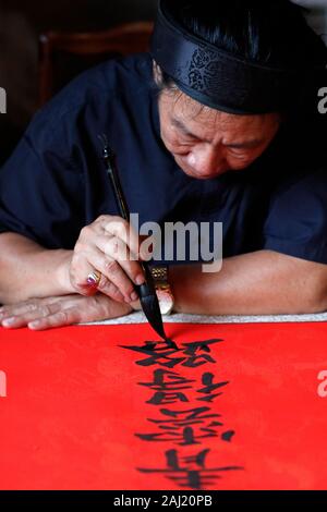 L'uomo facendo cinese tradizionale (scrittura) calligrafia in inchiostro utilizzando una spazzola, il Tempio della Letteratura, Hanoi, Vietnam, Indocina, Asia sud-orientale, Asia Foto Stock