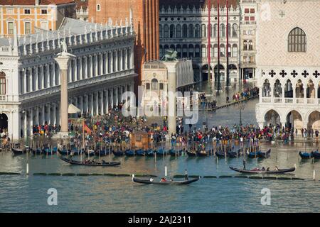 Vista in elevazione di una trafficata Piazza San Marco a Venezia durante l'alta marea con gondole allineate lungo la riva, Venezia, UNESCO, Veneto, Italia Foto Stock