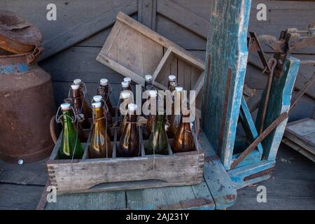 Vecchie bottiglie in una scatola su una bilancia Foto Stock