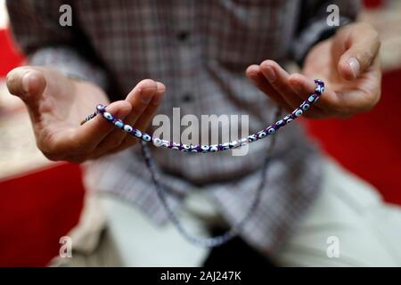 Close-up di uomo musulmano di pregare con la preghiera i talloni (Masbahah), Hanoi, Vietnam, Indocina, sud-est asiatico, AsiaClose-up. Foto Stock