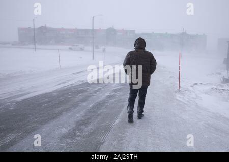 Blizzard a Longyearbyen, uomo a piedi nella neve. Svalbard, Norvegia Foto Stock