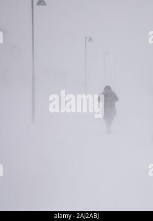 Blizzard a Longyearbyen, donna a piedi nella neve. Abstract sfocata inverno sfondo meteo Foto Stock