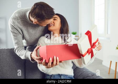 Il giorno di San Valentino. Una coppia giovane dà un dono in una stanza Foto Stock