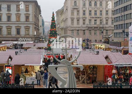 Budapest Ungheria Mercatino di Natale & tree in St Stephen square. Avvento festa festive decorazioni con di fronte alla folla stagionale tradizionale food & wine si spegne. Foto Stock