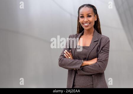 Ambiente caldo ed accogliente, bella allegro african american business executive donna presso l'area di lavoro di Office Foto Stock