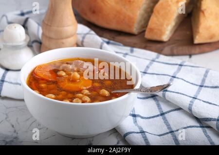 Zuppa di pollo, piselli, pomodoro e le carote affettate. Gustosa zuppa calda. Foto Stock