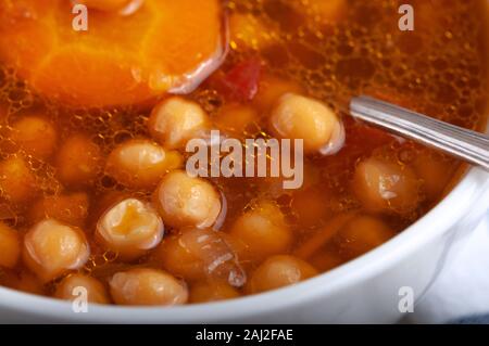 Zuppa di pollo, piselli, pomodoro e le carote affettate. Gustosa zuppa calda. Foto Stock