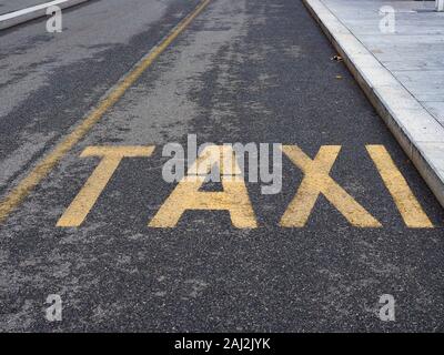 Yellow taxi segno dipinto sulla strada asfaltata Foto Stock