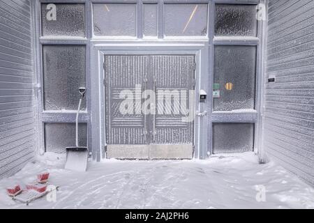 Ingresso del Radisson Blu Polar Hotel Spitsbergen, edificio ricoperto di neve e di gelo dopo forti ventoso tempesta di neve nevicata e la bufera di neve in inverno. Co Foto Stock