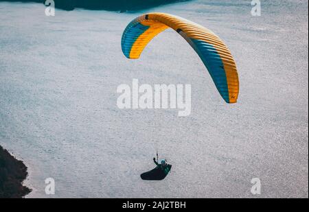 Parapendio oltre Nahuel Huapi lago e la città di Bariloche in Argentina, con vette innevate sullo sfondo. Concetto di libertà, avventura, battenti Foto Stock