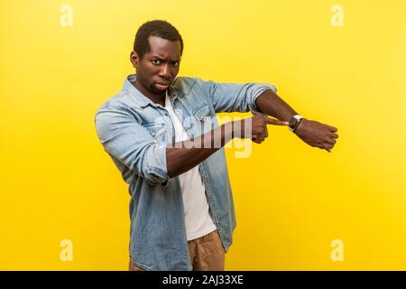 Guardare il tempo! Ritratto di irritato impaziente uomo in denim Camicia casual rivolti a orologi da polso, nervoso per essere in ritardo per la riunione, scadenza. Foto Stock