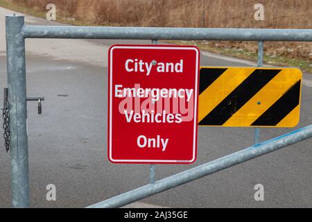 Burlington, Ontario, Canada, 2 gennaio 2020: Cartello rosso con le lettere che indicano solo la città e i veicoli di emergenza possono utilizzare questa strada asfaltata Foto Stock