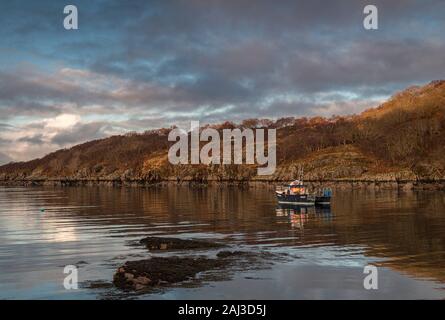 Un tranquillo inverno hdr tra parentesi la piena immagine di frame di una barca da pesca sul Loch Beag, vicino Shieldaig in Wester Ross, Scozia. 25 Dicembre 2019 Foto Stock